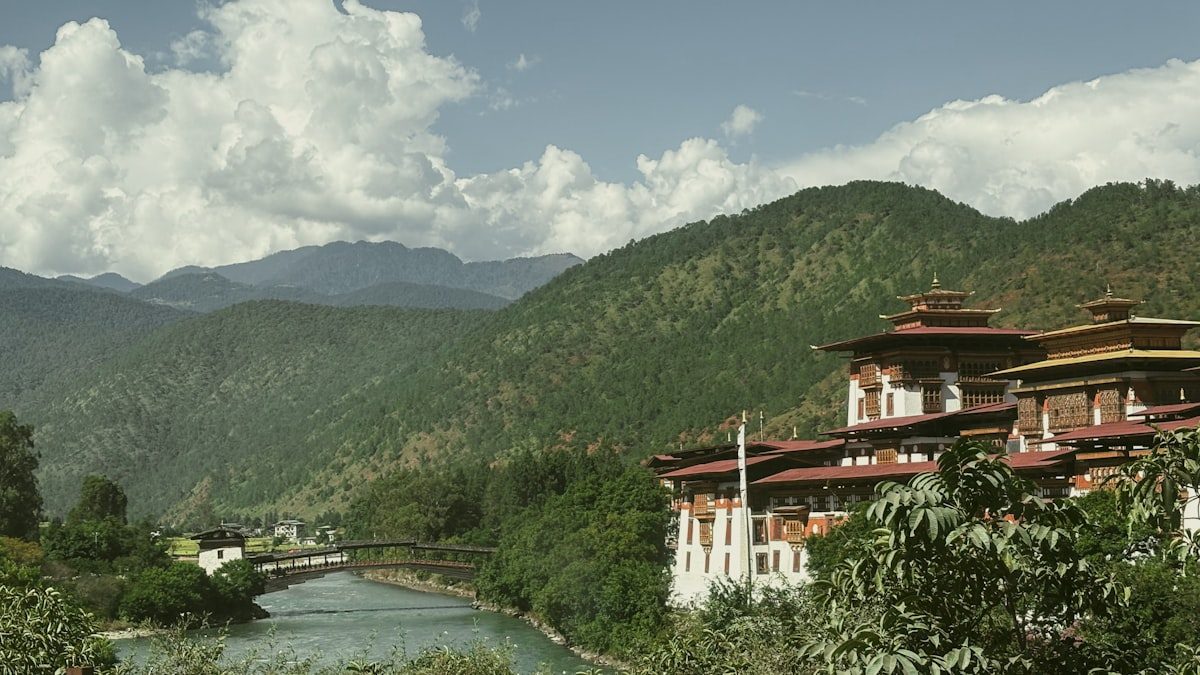 Traditional Bhutanese dzong beside a river and mountains in Paro
